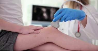 Travmatolog, klinikte diz eklemini ultrasonla muayene ediyor. Çocuk tanısı ve tedavisinde diz ağrısına yol açar.
