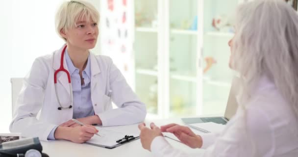 Kadın Doktor Dinliyor Yaşlı Kadın Kronik Hastalıklardan Bahsediyor Sağlık Şikayetleri — Stok video