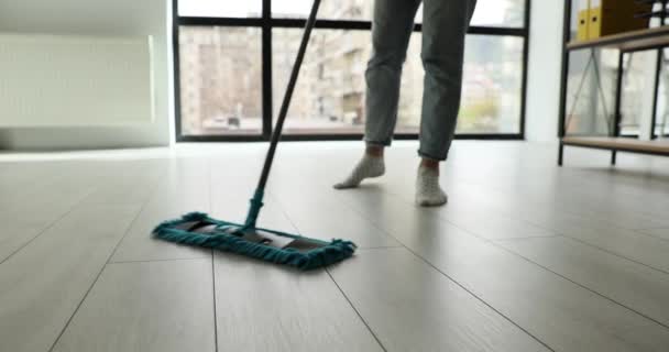 主婦はリビングやオフィスで湿ったモップで床をきれいにします 女性は自宅でラミネート床面から汚れを削除します — ストック動画