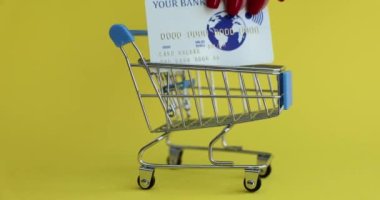 Kredi kartı bankacılığı ve online alışveriş yapan bir alışveriş arabası. Alışveriş kartı e-ticaret yaşam tarzı konseptine para harcayın