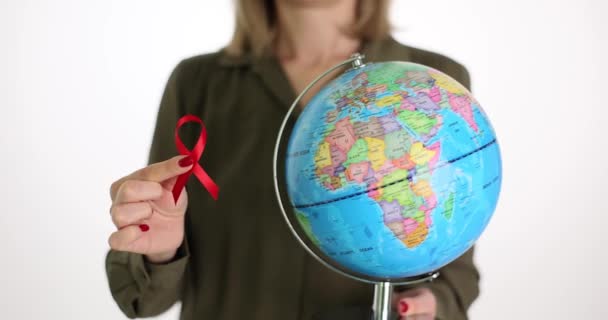 世界エイズデー女性の手の中にHiv世界 赤いリボンと地球のシンボル — ストック動画