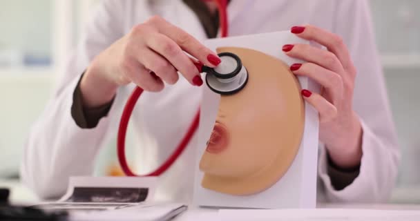 女医生在临床上将听诊器应用于现实的乳房模型 肿瘤学家和乳腺专家会诊 — 图库视频影像