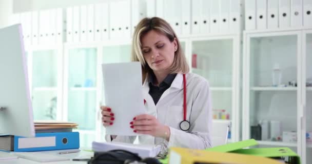 女性医師は診療所に書類を入れます 医療文書の登録 — ストック動画