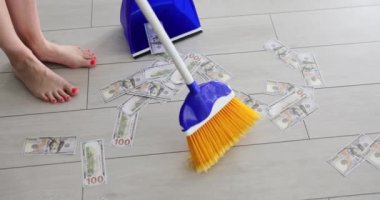 Süpürgeyle ev hanımı, kağıt dolarları yakın plan mavi faraş ile süpürür. Mali kriz ve ekonomik temerrüt kavramı