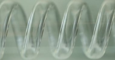 Beyaz arka planda cam kimya laboratuvarı ekipmanları sarmalı. Tıbbi deneyler için ekipman. Laboratuvar için cam spiral.
