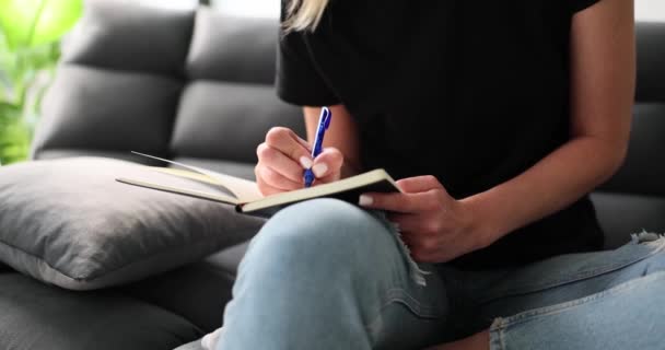 Γυναίκα Γράφει Σημειωματάριο Ημερολόγιο Ημερολόγιο Στυλό Και Κάθεται Στον Καναπέ — Αρχείο Βίντεο