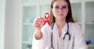 AIDS 'le ilgili kırmızı kurdele Dünya HIV ve AIDS Günü için doktorun elinde. İnsan bağışıklık yetmezliği virüsü ve tedavisi