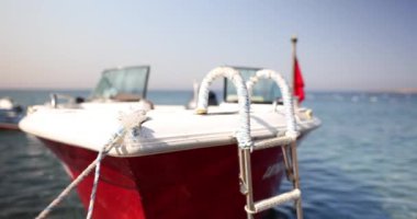 Tahta beyaz tekne demirli ve okyanusta yüzüyor. Boş tekne denizin dalgalarında sallanıyor.