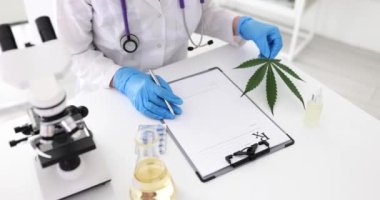 Doktor ağrı kesici için CBD yazıyor ve marihuana yaprağı tutuyor. Doktor elinde tıbbi marihuana tutuyor, hastalara tıbbi marihuana ve yasal hafif ilaçlar öneriyor.