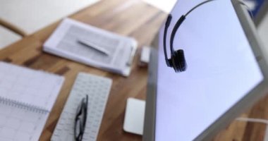 Mola sırasında bilgisayar ekranında modern kablosuz kulaklıklar. Çevrimiçi operatör veya içişleri bakanlığının işyeri organizasyonu
