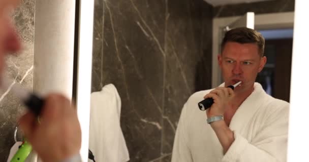 Homem Escova Dentes Com Uma Escova Dentes Elétrica Banheiro Visão — Vídeo de Stock