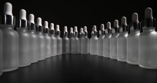 一组血清瓶 带有分离于黑色背景的吸盘 护肤化妆品用结霜玻璃瓶的封堵 — 图库视频影像