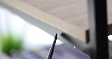 Metal rafı ya da merdiveni siyah fırçayla boyayacak kişi. Sanayi sanatçısı iş başında.