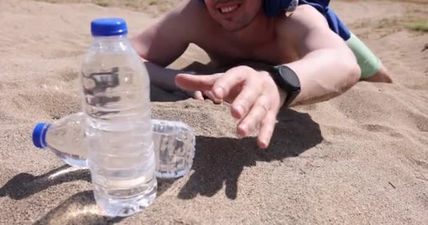 Homme Déshydraté Atteint Une Bouteille Eau Tout Étant Couché Sur — Video