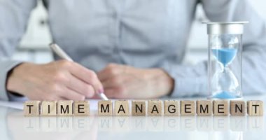 İş kadını ve kum saati, yazıt yönetiminin yanındaki masada duruyor. 4K film kapanıyor. Çalışma saatleri kavramı