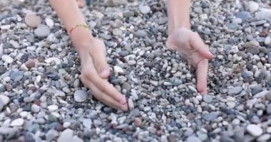 Çocukların elleri avuçlarında küçük çakıl taşları toplar, yakın plan. Pediatrik terapi, el manipülasyonu