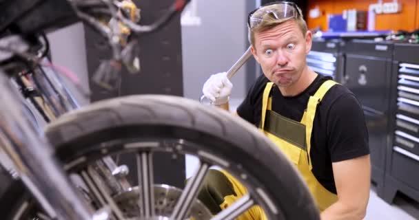 Emotionally Pensive Auto Mechanic Holds Wrench Stares Surprise Motorcycle Service — Vídeos de Stock