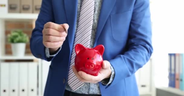 Businessman Tosses Coin Piggy Bank Saving Increasing Savings Concept — Stock Video