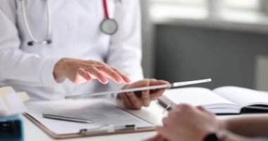 Doktor, klinikte hastayla birlikte çalışıyor. Teşhisi tabletten öğreniyor. Sağlık ve sağlık hizmetleri kavramı