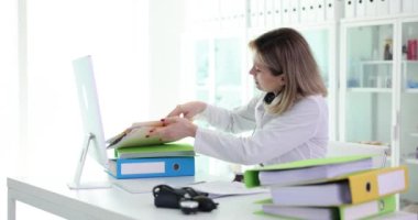 Doktor çalışıyor ve klinikte tıbbi belgeler arıyor. Tıbbi belgeler ve dizinler