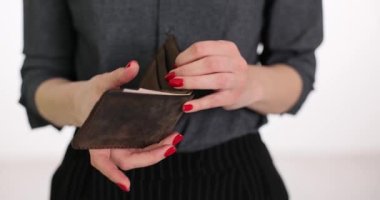 Kadın cüzdanı elinde tutuyor ve alışveriş yapmadan önce 50 dolar sayıyor. Cüzdanında dolar olan ve aile bütçesi planlayan biri.