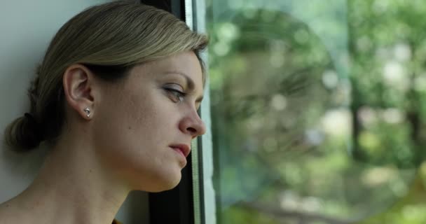 悲しい挫折した若い女性が窓のそばに座っている デユスカは孤独の心の崩壊について考える — ストック動画