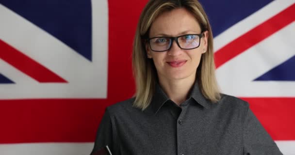 英国の国旗を背景に美しい笑顔の女性の肖像画 イギリスの教育と市民権 — ストック動画