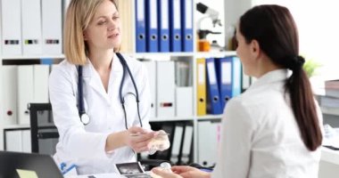 Mutlu kadın göğüs implantı olan bir estetik cerrahı dinliyor, yakın plan. Klinikte meme bakımı.