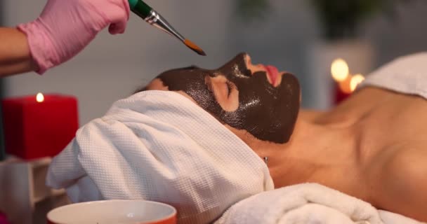 Cosmetologist Applies Mask Brush Face Lying Woman Close Chocolate Face — Vídeos de Stock