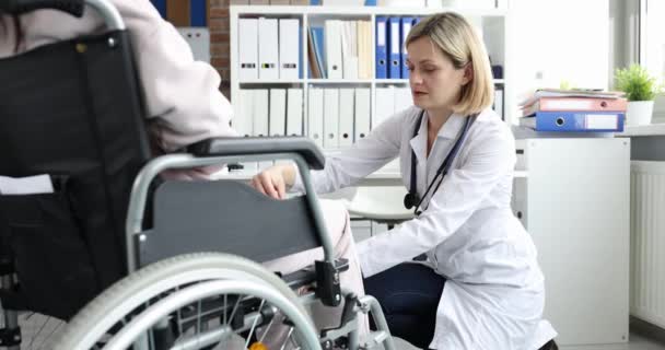 Female Doctor Hits Knees Woman Wheelchair Hammer Checking Reflex Injury — 图库视频影像
