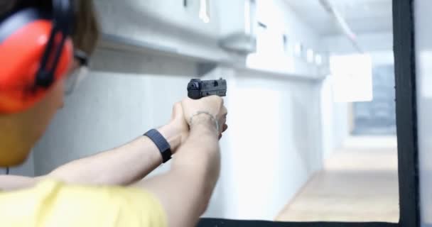 Chlápek Sluchátkách Střílí Zblízka Cíl Uvnitř Pistolový Střelecký Výcvik Vojenský — Stock video