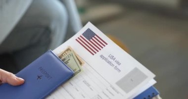 İnsanlar, Amerikan vizesi almak için belgelerle sırada oturuyorlar. 4K 'lık yakın çekim filmi ağır çekim. Yurtdışına seyahat konsepti için belge sunma