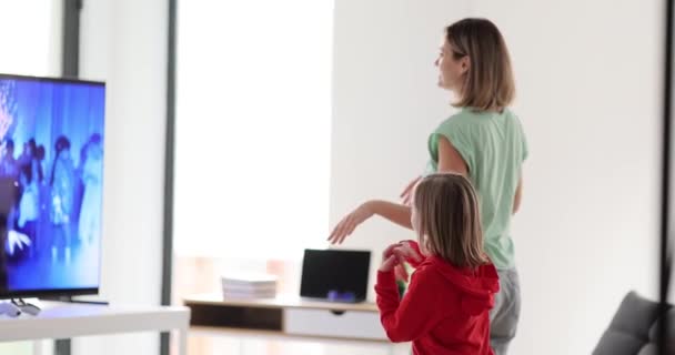 母亲和女儿在家里的电视机前跳舞和玩耍 健身舞蹈概念的电视应用 — 图库视频影像