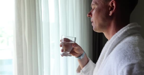 Молодий Чоловік Чисту Воду Захоплюючись Видом Вікна Починаючи День Харчування — стокове відео
