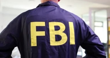 FBI üniformalı bir FBI ajanı arkada duruyor. Amerika 'daki Federal Araştırma Bürosu