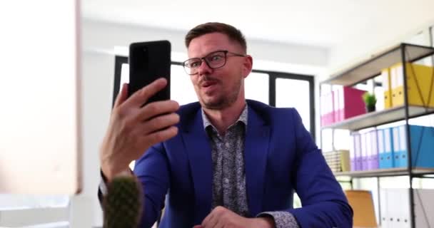 Biznesmen Rozmawiający Kamerą Telefoniczną Robiący Emocjonalne Grymasy Wirtualne Żarty Pozdrowienia — Wideo stockowe