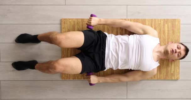 运动的年轻人在家里用一对哑铃在垫子上锻炼和做举重运动 健康和健身运动 — 图库视频影像