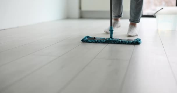 女性の人は モダンな波スローモーションを使用して白い木製の床をモップします 綿の靴下の女性は家の衛生をサポートします — ストック動画