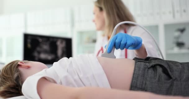 好心的女医生用超声波检查患有胃病的小女孩 小心的女人看着屏幕 里面有病人慢动作的腹部图像 — 图库视频影像