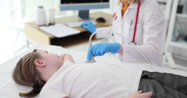 白衣の医師は超音波凸線形変換器を用いて女子高生の心臓を調べる 女性医療専門家は 患者の心血管系の状態をチェック — ストック動画