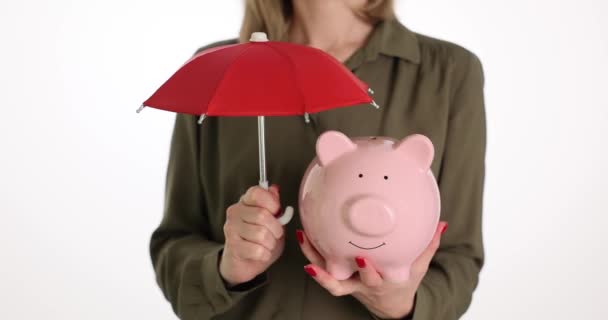 Žena Drží Růžovou Prasátko Banku Pod Červeným Deštníkem Jako Pojistku — Stock video