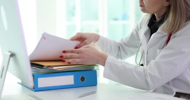 Kadın Aile Doktoru Hastane Ofisindeki Çalışma Masasında Çalışma Kağıtlarının Arasında — Stok video