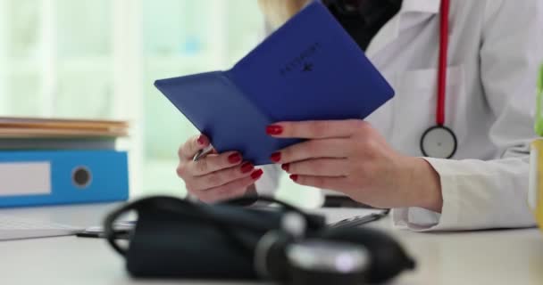 女性医師は クリップボードにデータを書き出すために独自のパスポートを開きます 医療専門家がビザ申請書に記入休暇を海外で計画 — ストック動画