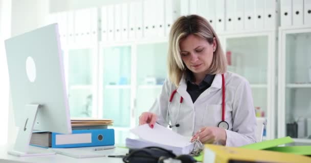 女性の医療は 患者データストレージ用のフォルダに紙文書を挿入します 職場の専門家の分類とワークフローの概念 — ストック動画
