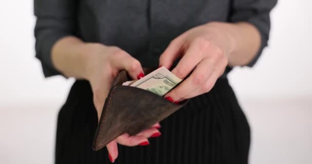 赤いマニキュアを持つ女性は スタジオの明るい背景に革財布のドル紙幣をカウントします 貯蓄とキャッシュカウントの概念スローモーション — ストック動画