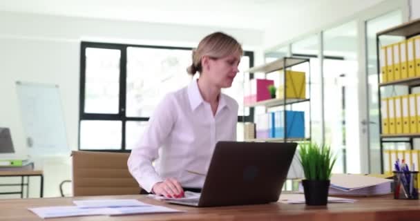 女性のオフィスワーカーは 長い時間がラップトップで作業した後に立ち上がり 目に暗くなる攻撃を受けます メガネのない技術で作業するためのビジョン損失 — ストック動画