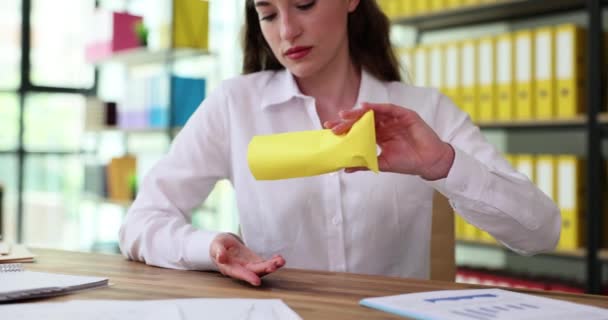 衝撃的な女性のオフィスワーカーは文書とテーブルに坐る予想された給与の代りに封筒から白い粉を注ぐ 給与の遅れ 満たされない期待の概念 — ストック動画