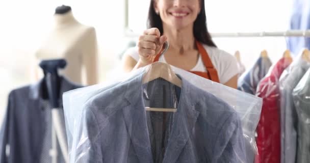洗濯4K映画のビニール袋にクリーンな服をクライアントに与える女性 服の修理コンセプト — ストック動画