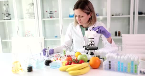 Kobieta Naukowiec Bada Strukturę Substancji Owocowych Pomocą Mikroskopu Zapisuje Wyniki — Wideo stockowe