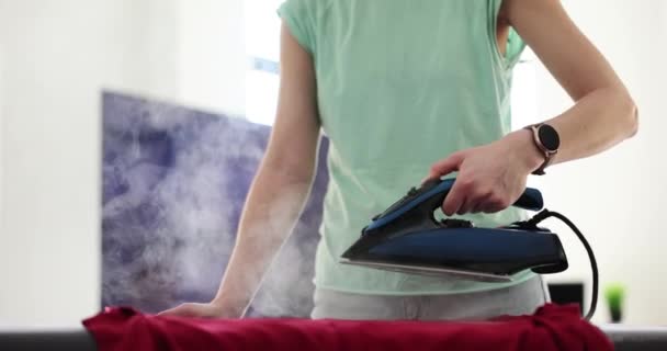 アイロン台の上で洗濯された衣類をアイロン装置から蒸気が出てきます 毎日の家事を行う女性の概念アイロン服スローモーション — ストック動画
